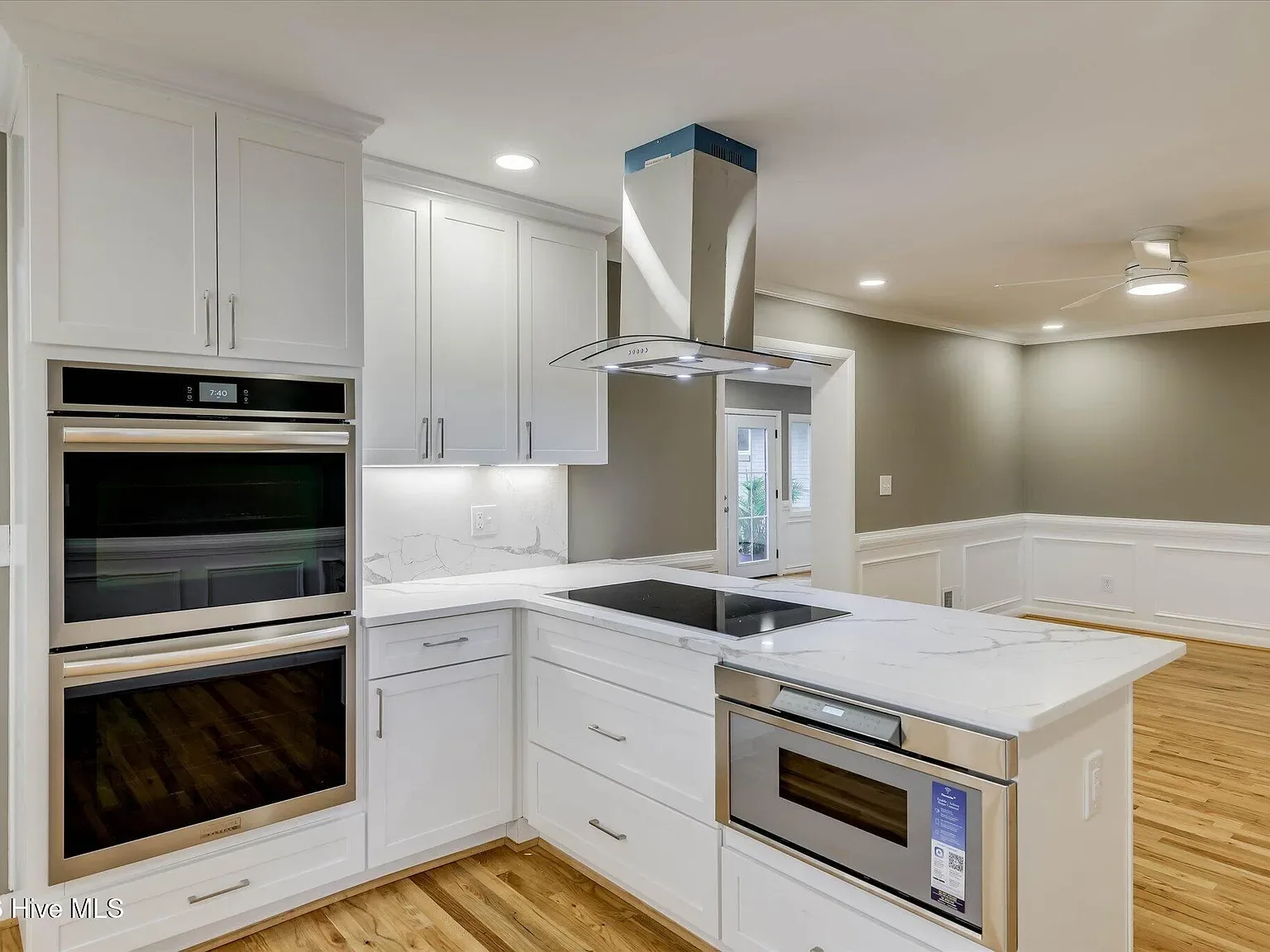 Renovated kitchen with a center island, vent hood and double wall ovens at 1135 Crestview Avenue