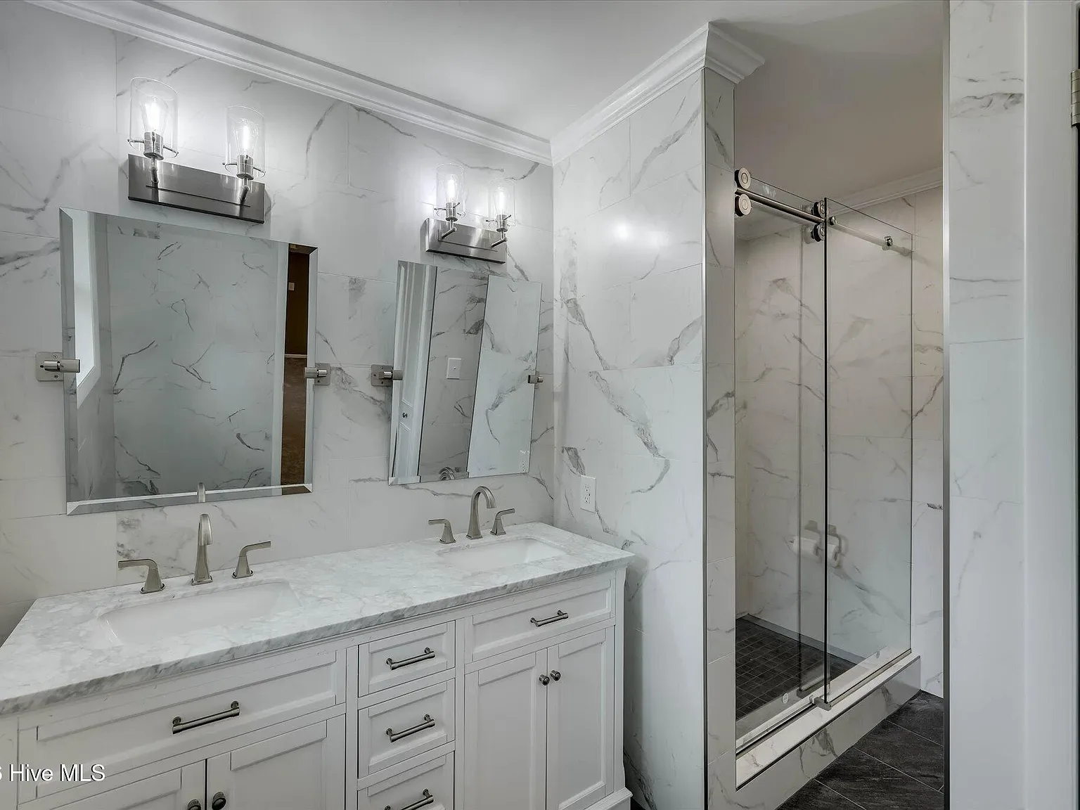 Marble-look bathroom with a double vanity and glass shower at 1135 Crestview Avenue