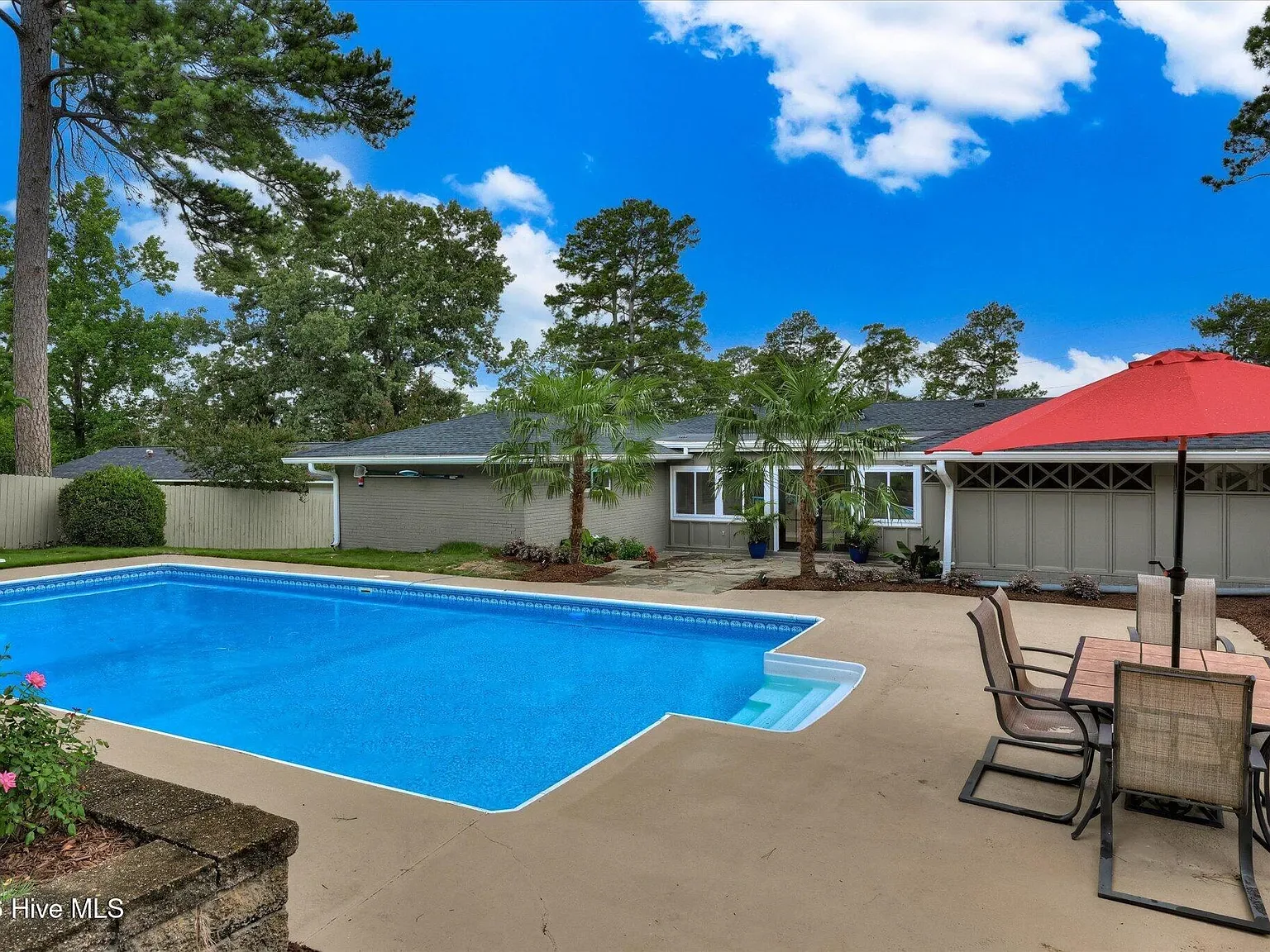 Poolside seating with umbrella in the rear yard at 1135 Crestview Avenue