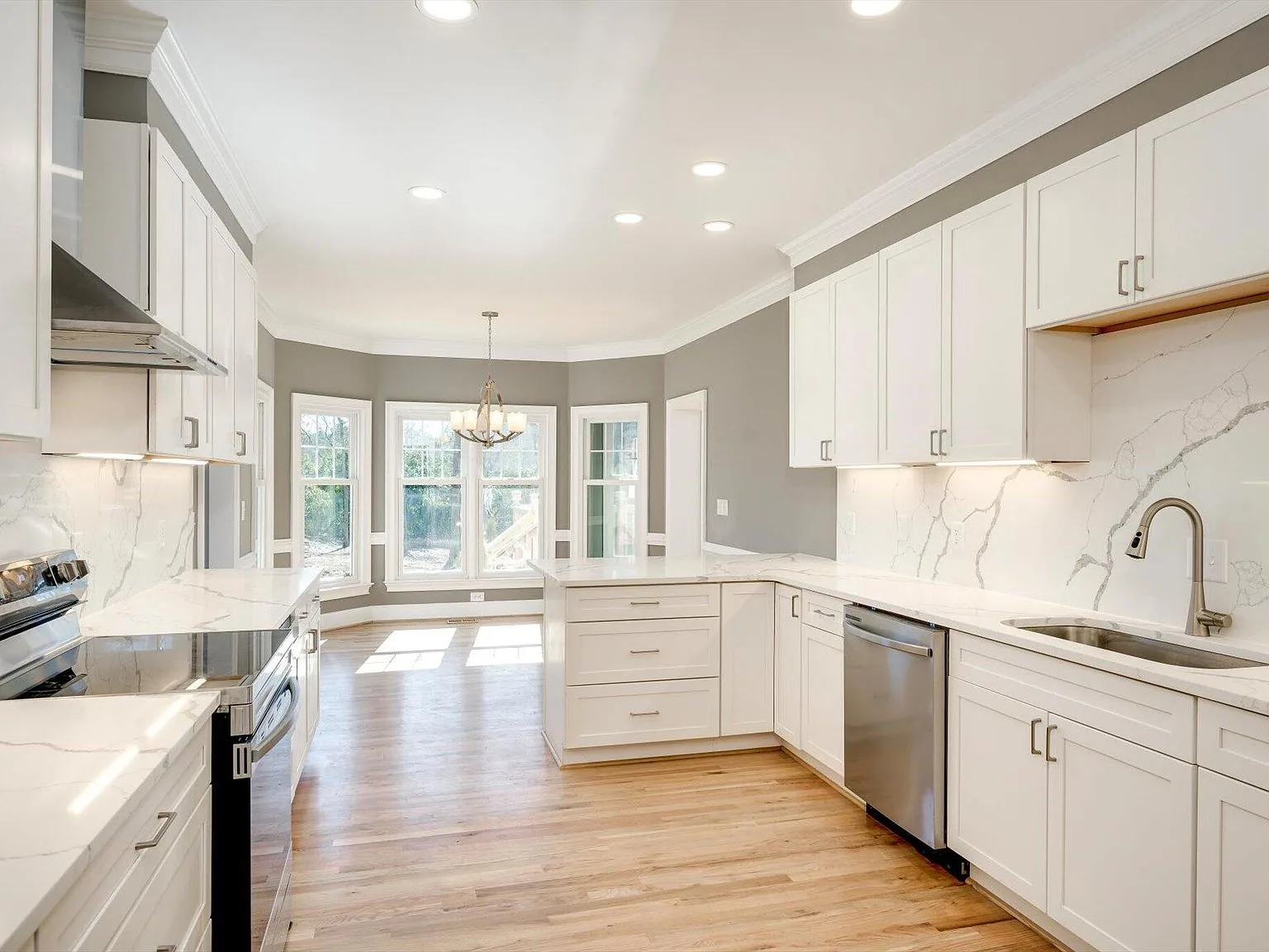 Renovated open kitchen with center island, white cabinetry and hardwood floors at 2 Shadowmoor Court in North Augusta