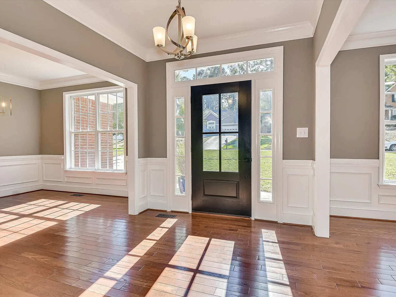 Entry foyer with refinished hardwood, wainscoting and a new chandelier at 2008 Rivershyre Drive