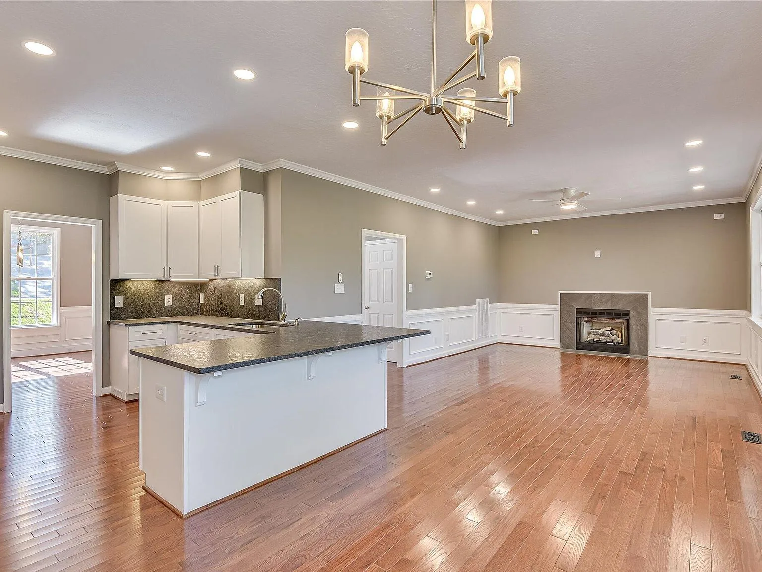 Open kitchen looking into the living room with a stone fireplace at 2008 Rivershyre Drive