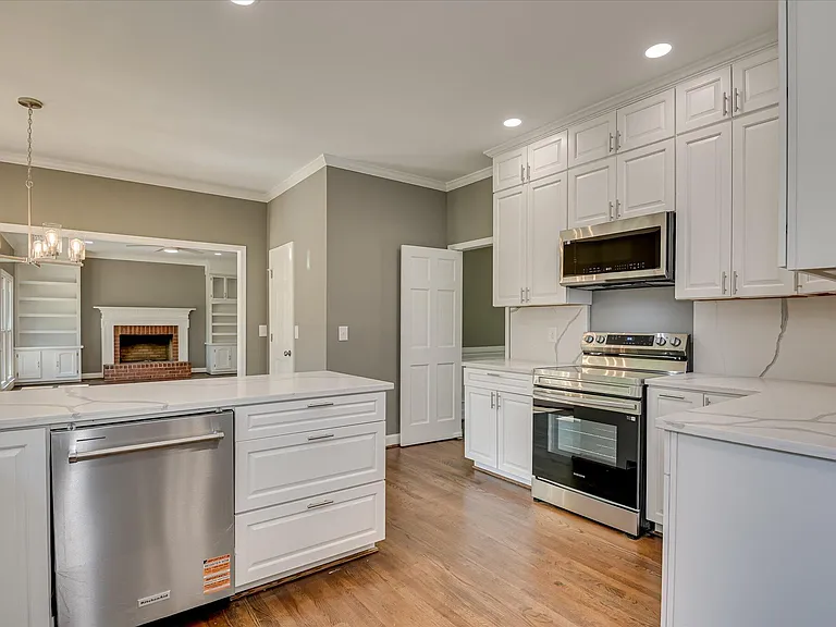 Renovated kitchen with island, stainless appliances and hardwood flooring at 4 Shadowmoor Court