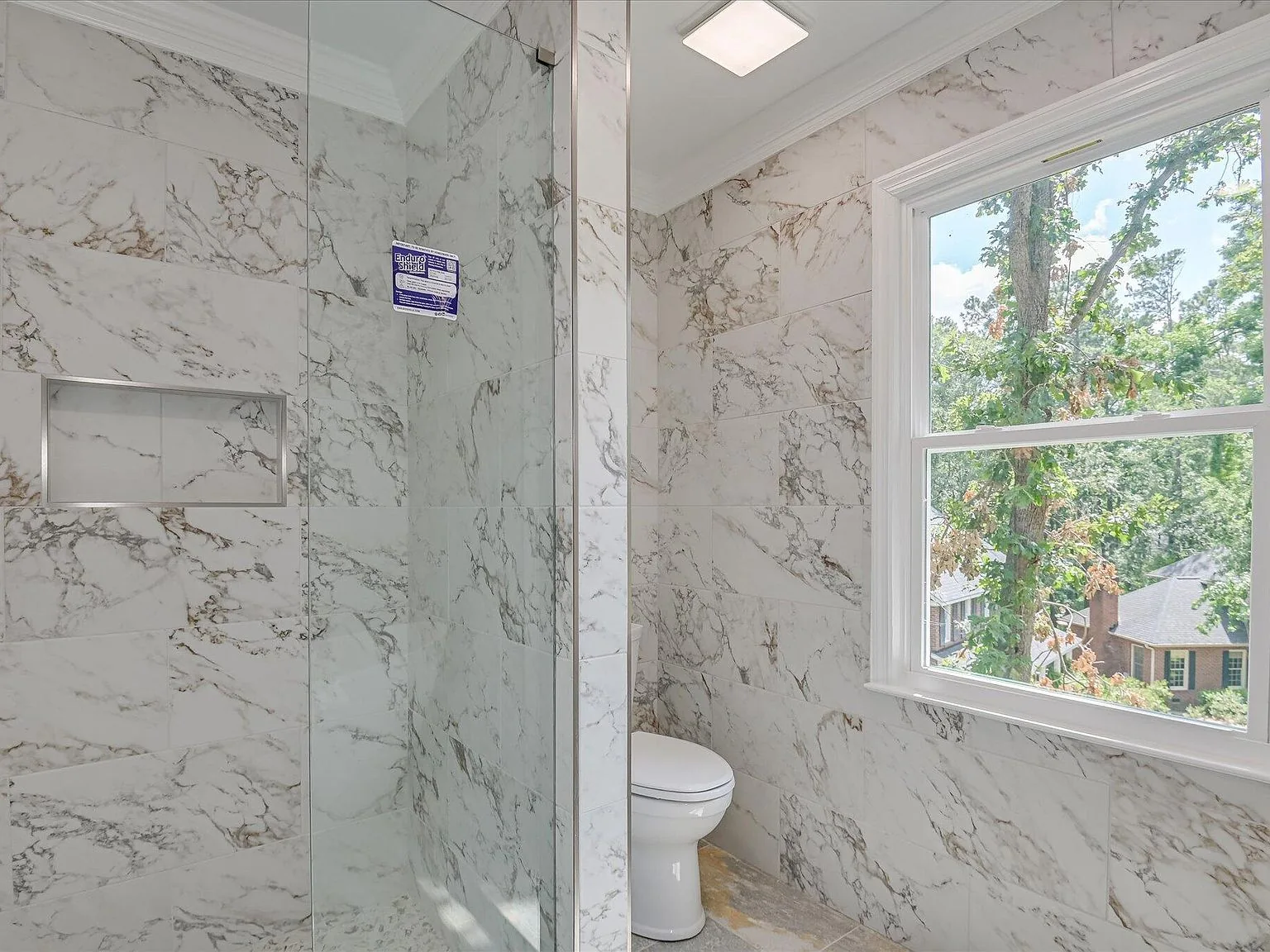 Primary bath walk-in shower and marble tile at 4 Shadowmoor Court