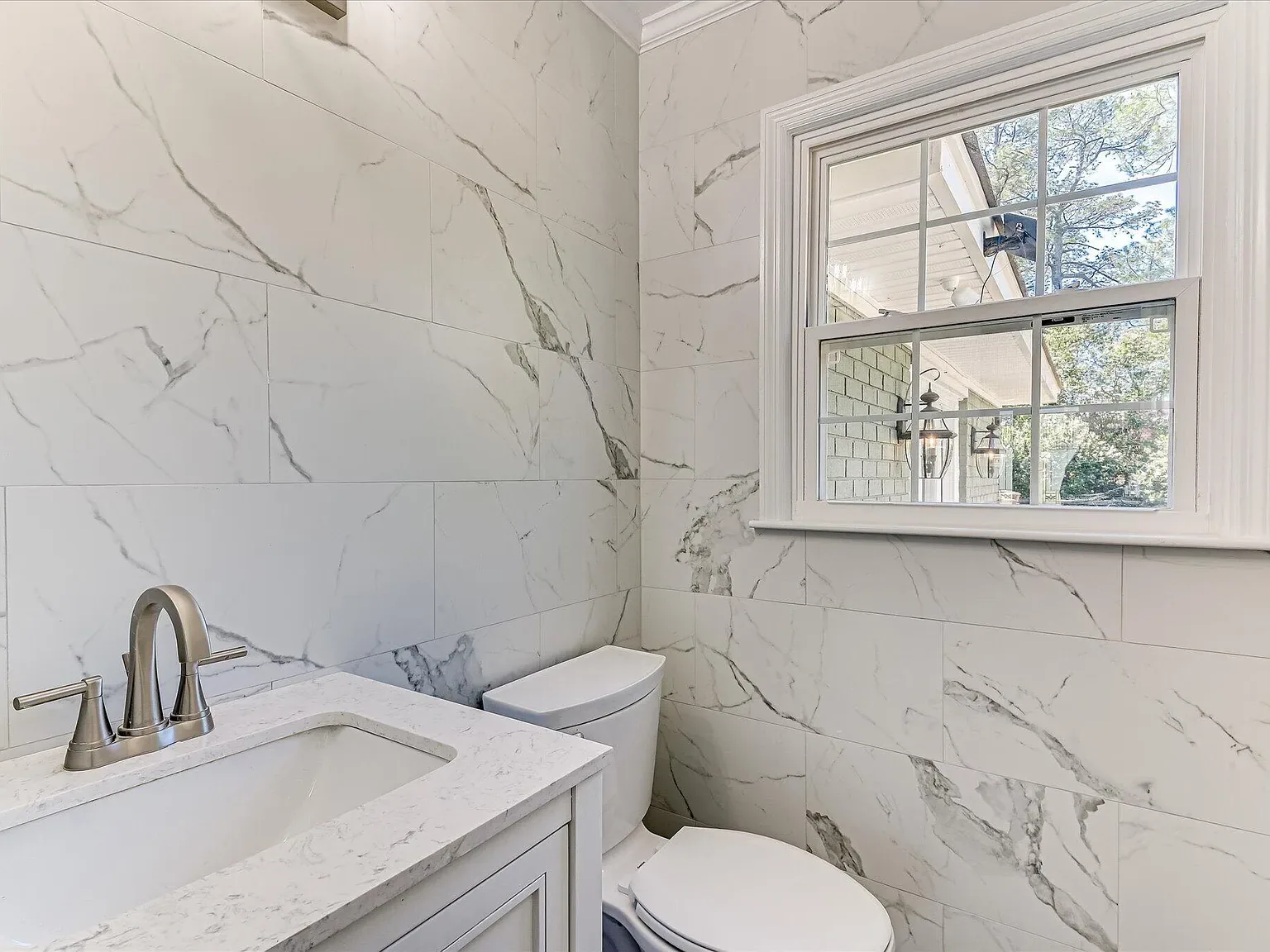 Bathroom vanity with quartz top and marble-look tile at 814 Dunbarton Drive
