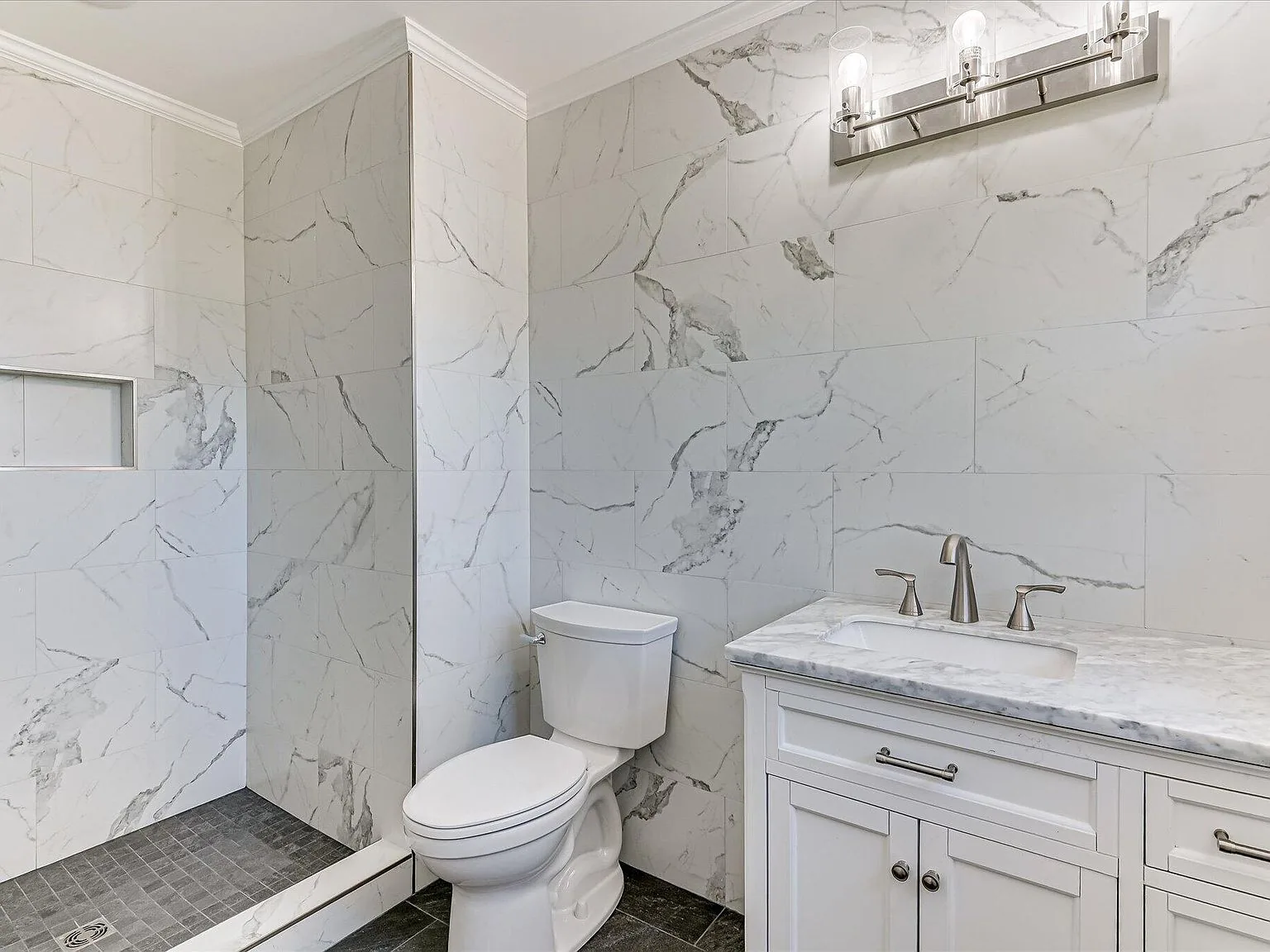 Primary bath with marble-look tile walls and quartz vanity at 814 Dunbarton Drive in North Augusta