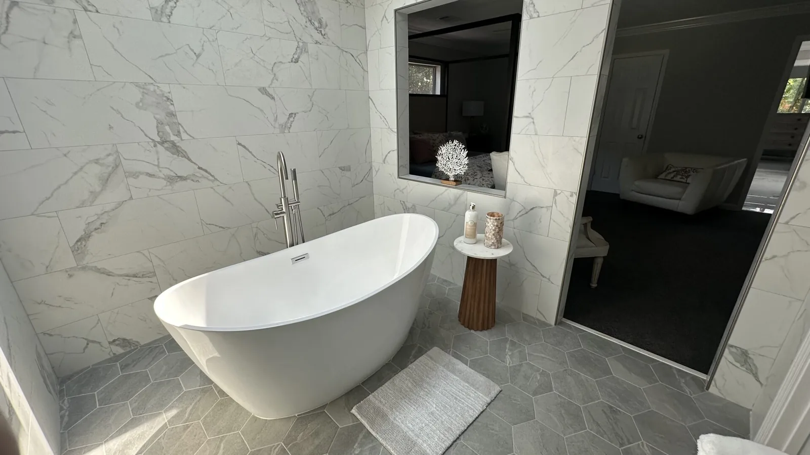 Primary bathroom with freestanding soaking tub and marble-look tile at 2417 Wilkshire Drive